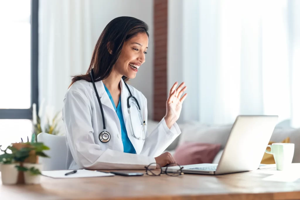 female doctor waving during online consultation at utc ()